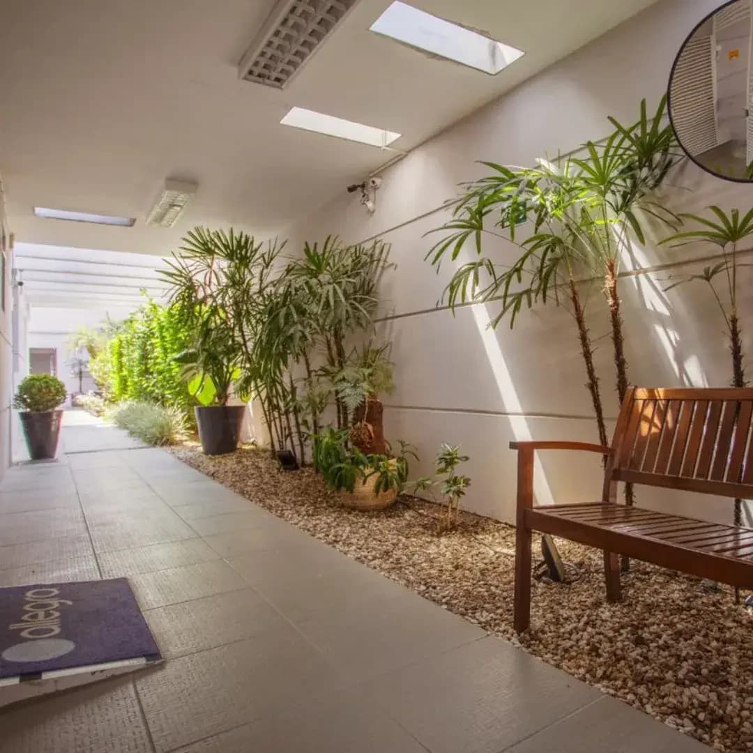 Jardim interno da Allegra Odontologia com plantas e iluminação natural.