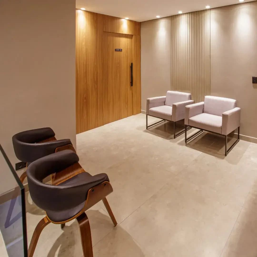 Sala de espera da Allegra Odontologia com poltronas e acabamento em madeira.